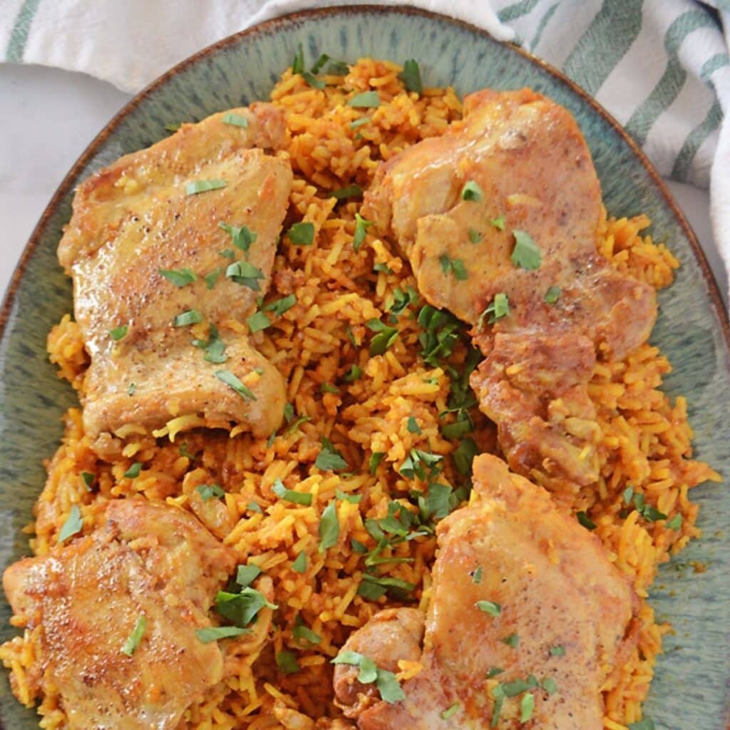 A top view of kabsa dish garnished with chopped parsley.