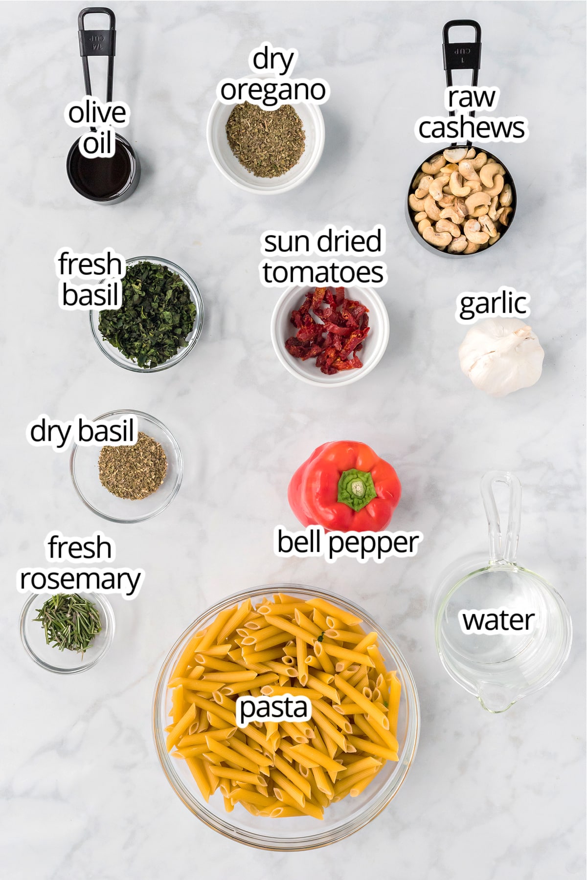 Pasta ingredients on a white marble surface.