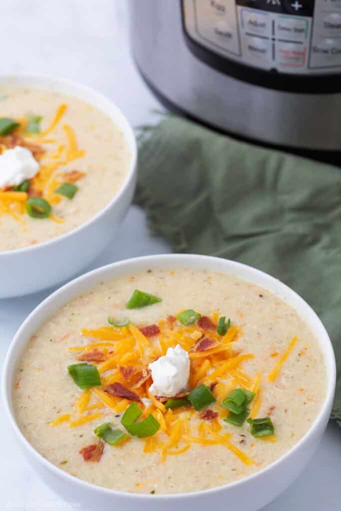 Two bowl of potato soup with the instant pot in the back.