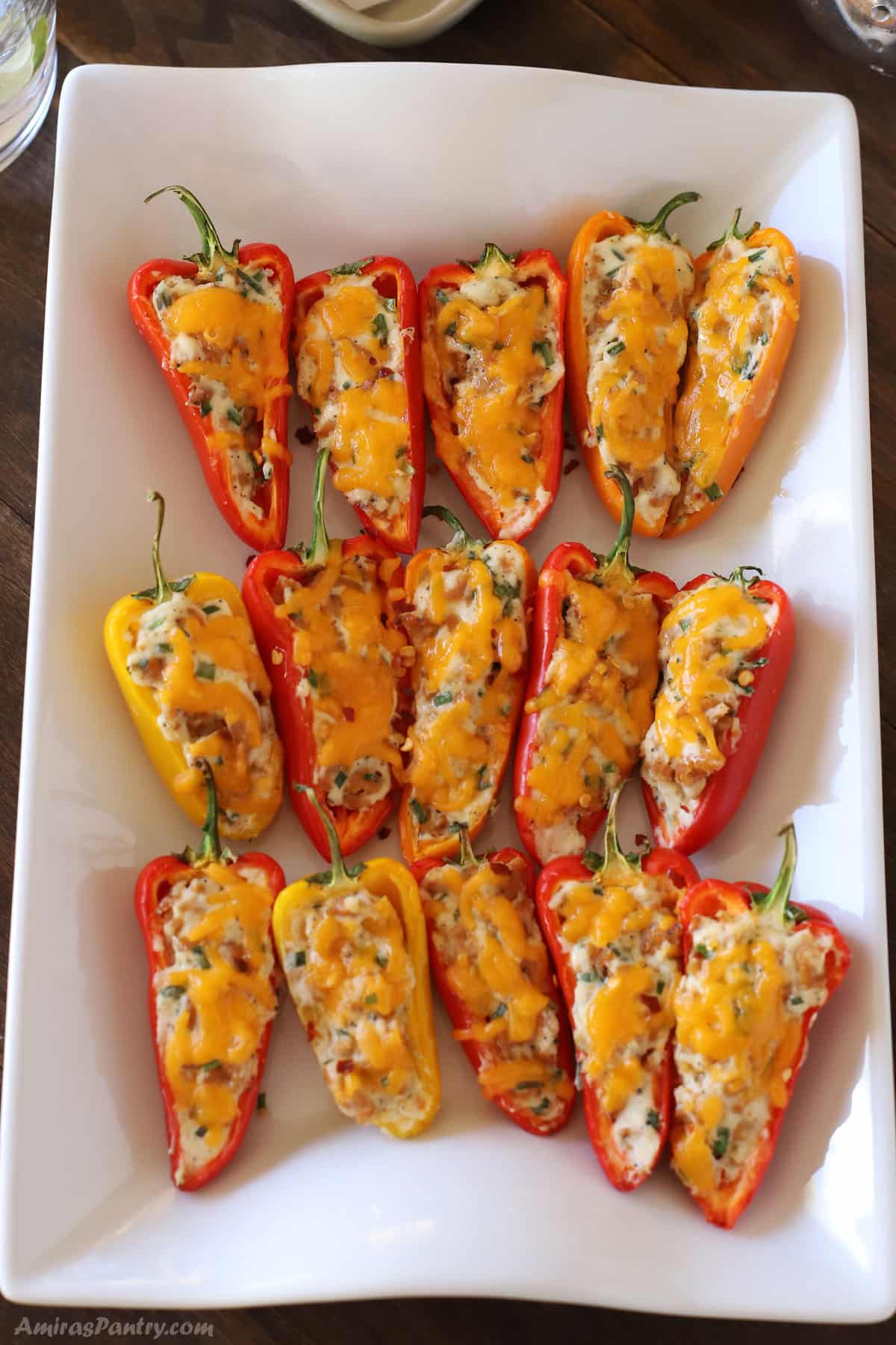 A white serving platter with stuffed sweet peppers.