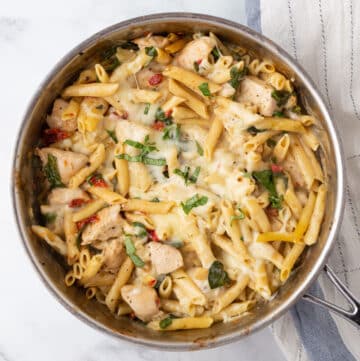 A top view of a skillet with creamy tuscan chicken pasta.