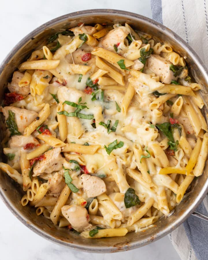 A top view of a skillet with creamy tuscan chicken pasta.