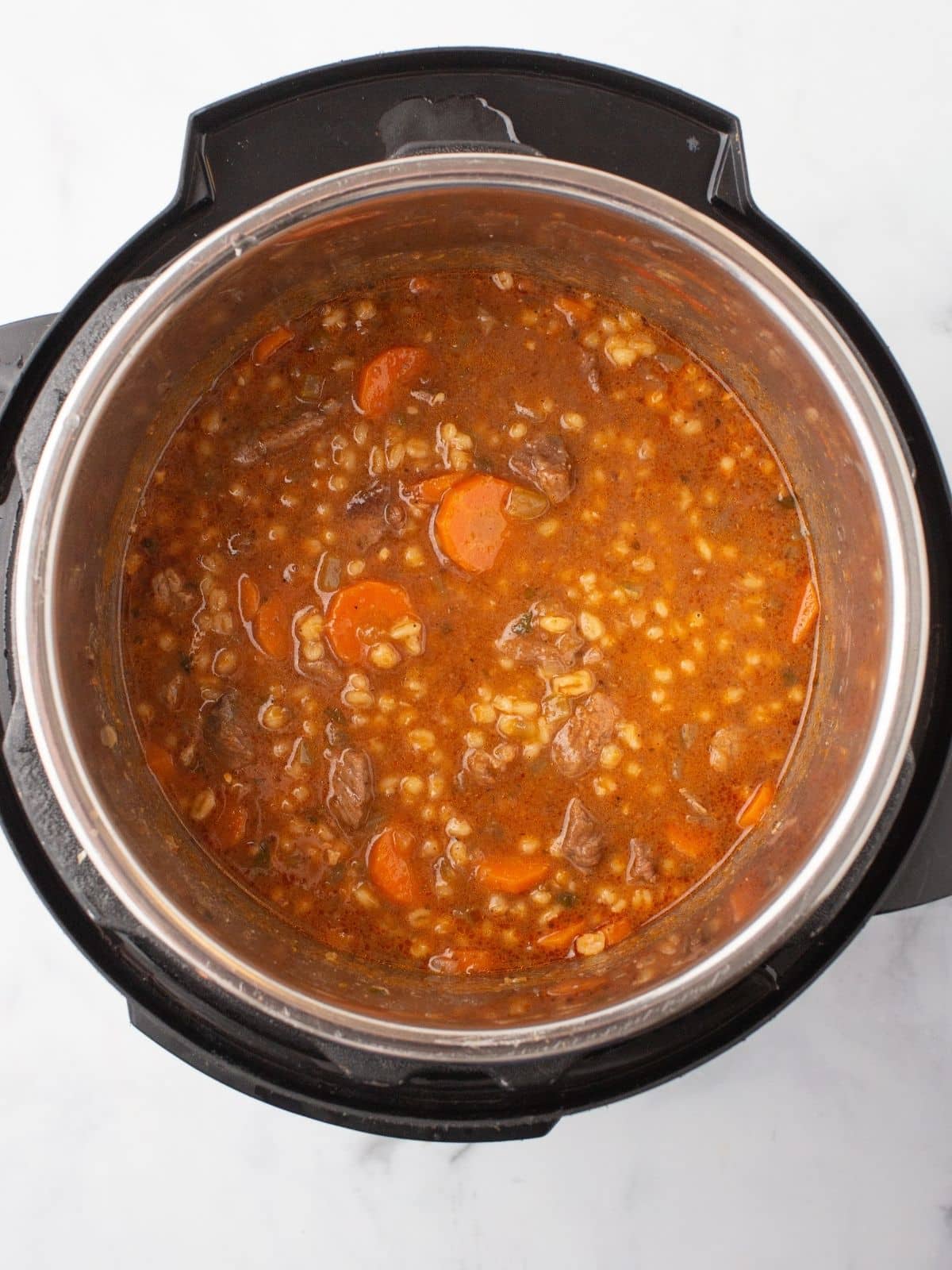 An instant pot with barley soup.