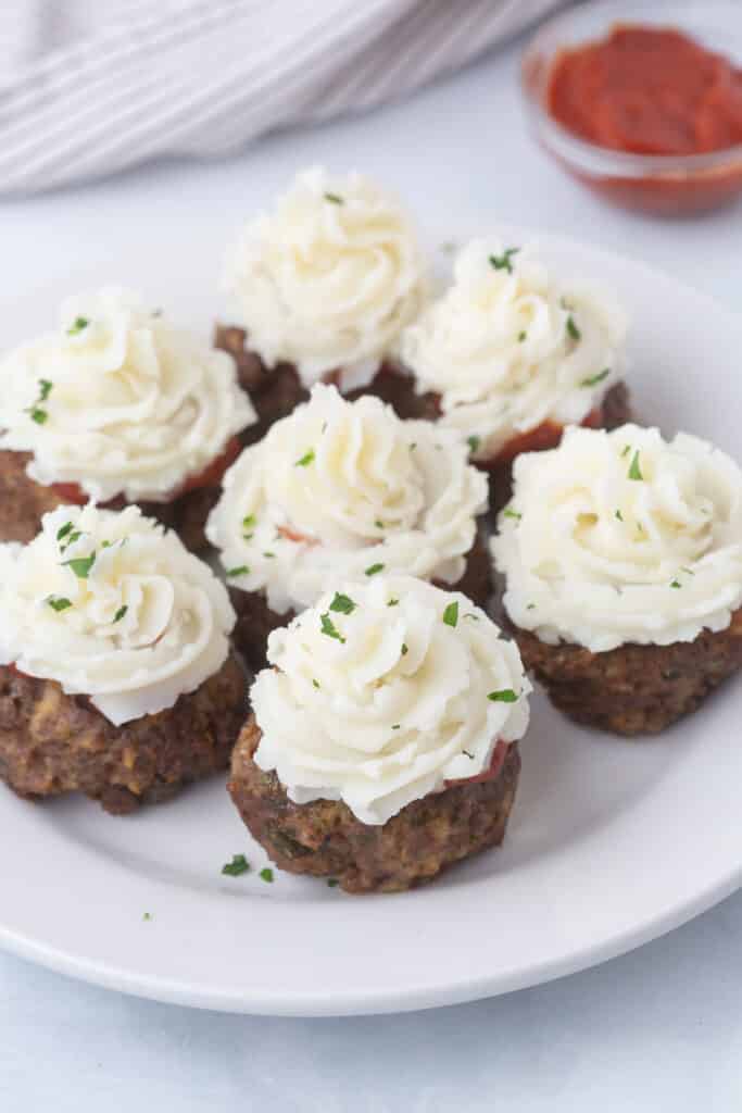 Meatloaf cupcakes on a white plate.