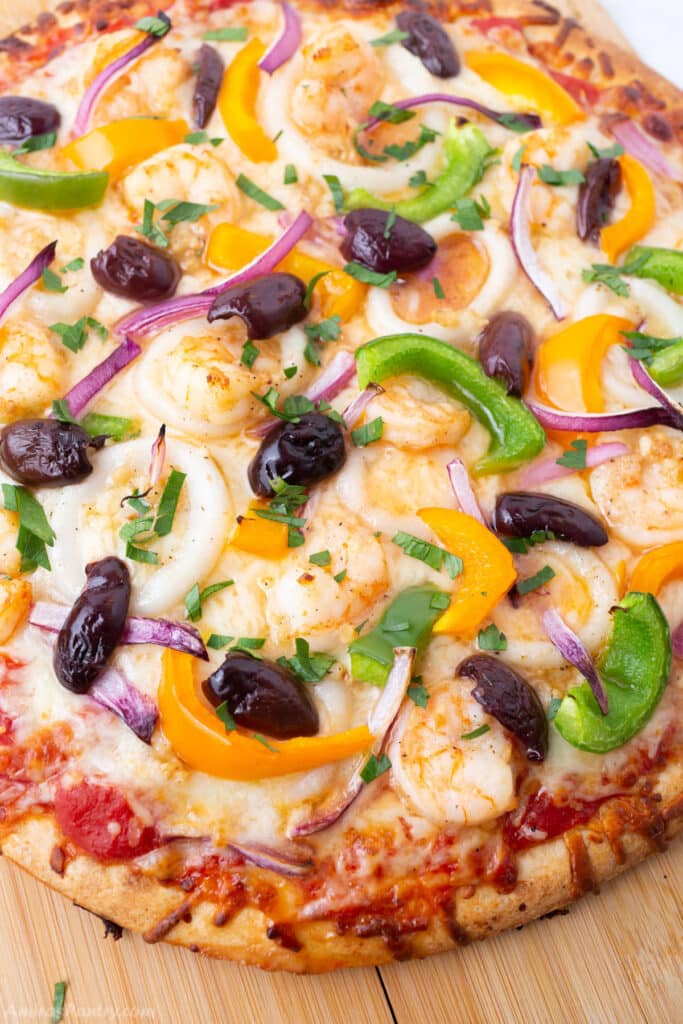 A close up look at a pizza on a wooden surface.