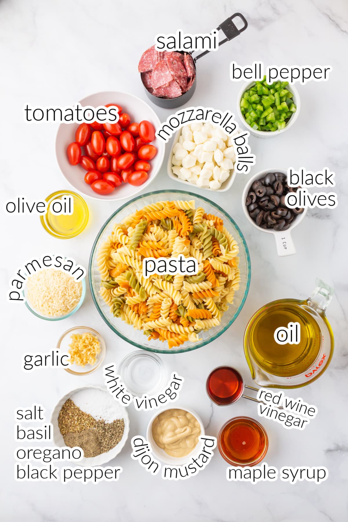 Italian pasta salad ingredients on a white table.