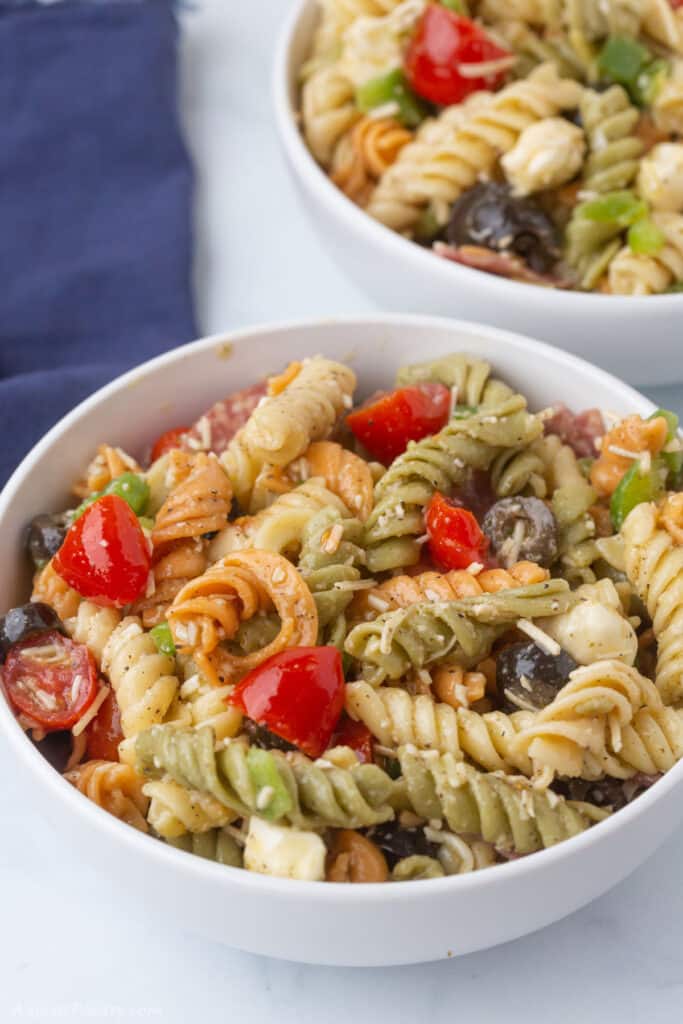A close look at a white bowl with Italian pasta salad.