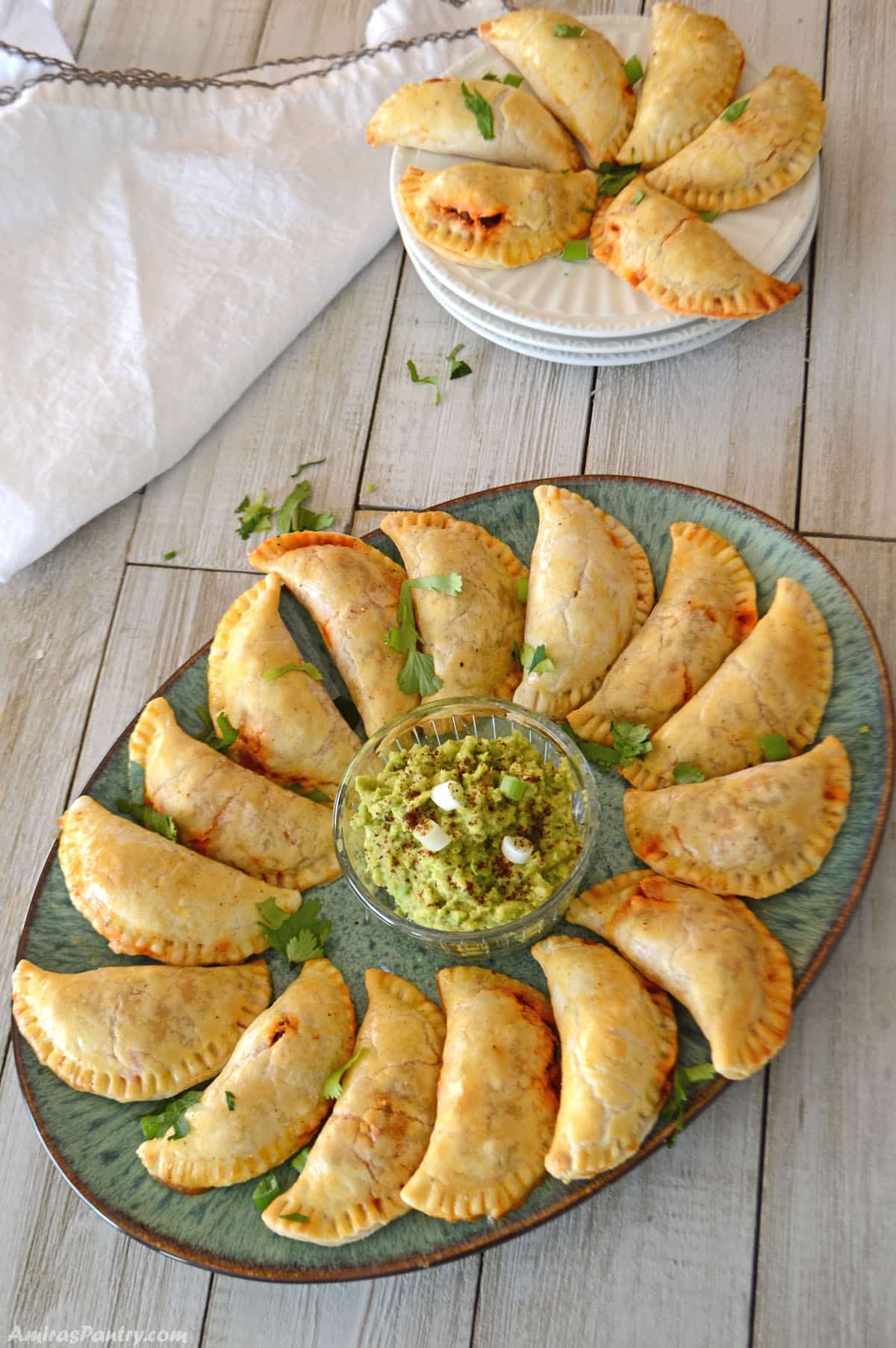 A top view of a green platter with beef empanadas.