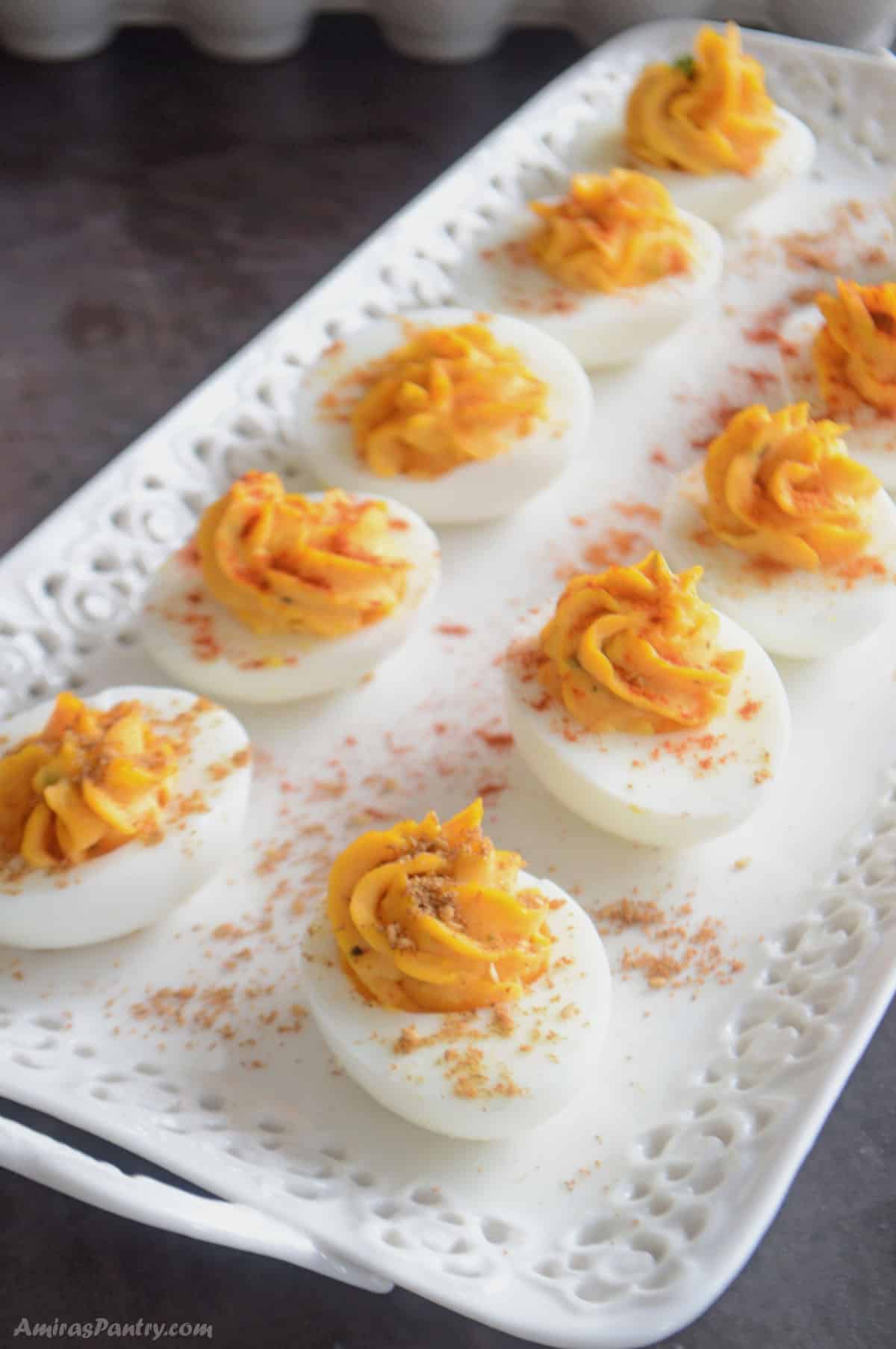 Deviled eggs placed on a white serving plate.