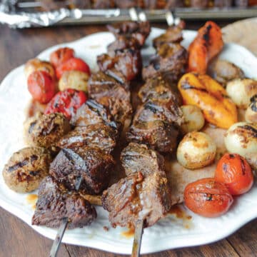 Kabob skewers on a white plate.
