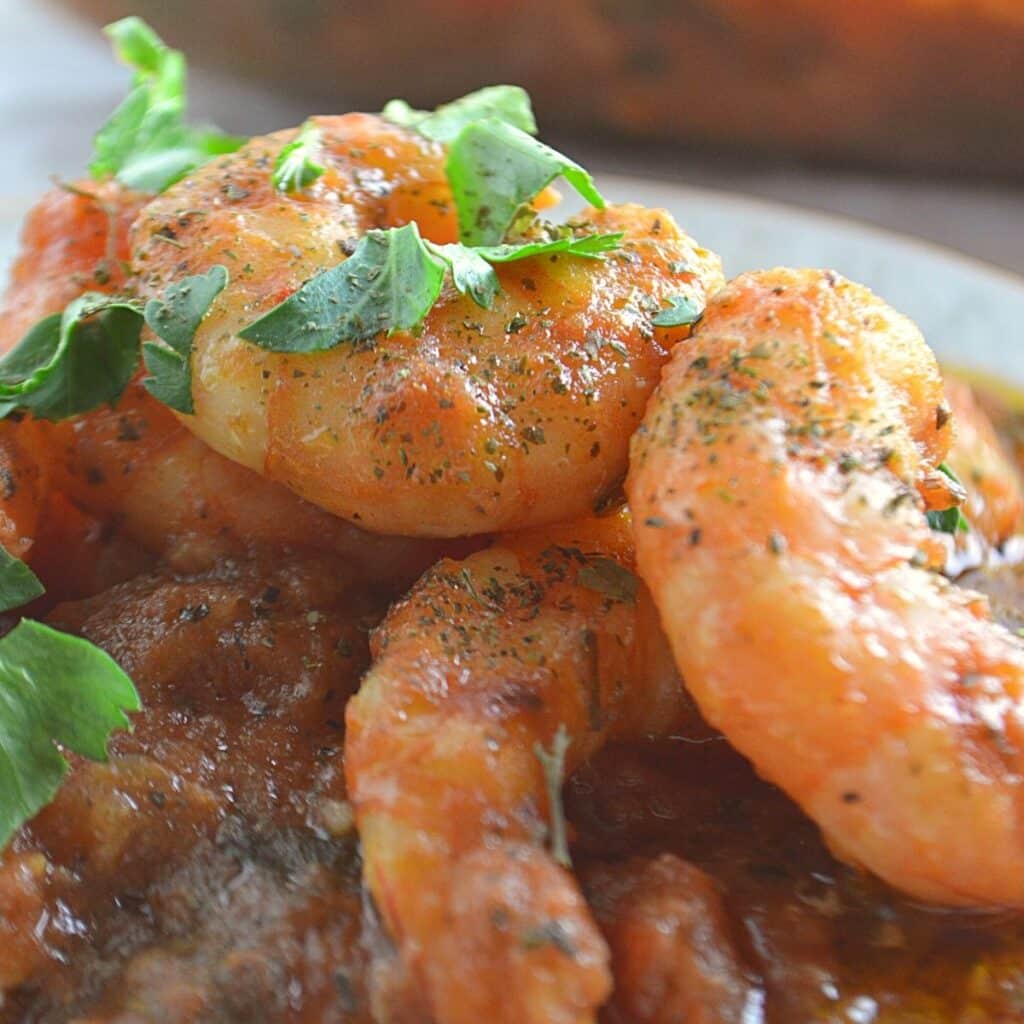 A close up look at a plate with shrimp stew.