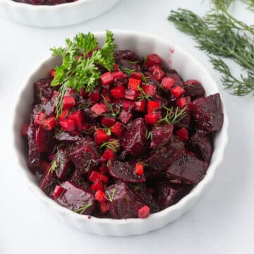 A white bowl of beets and carrot salad.