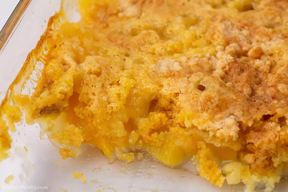 A close up look at a casserole dish with peach cobbler.