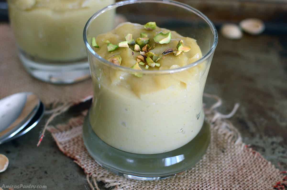 A cup with freshly made pistachio pudding garnished with crushed pictashios.