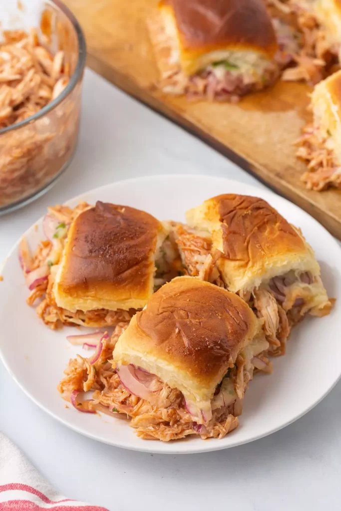 Three bbq sliders on a white plate.