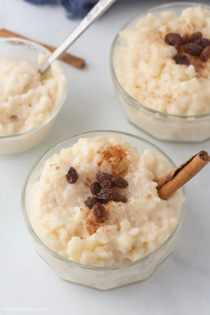 An overhead view of some bowl with rice pudding garnished with cinnamon and raisins.