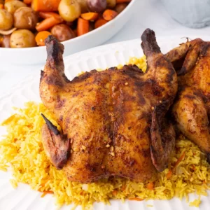 A close up look at a dish with yellow rice and chicken.