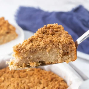 A slice of apple crumb cake being served.
