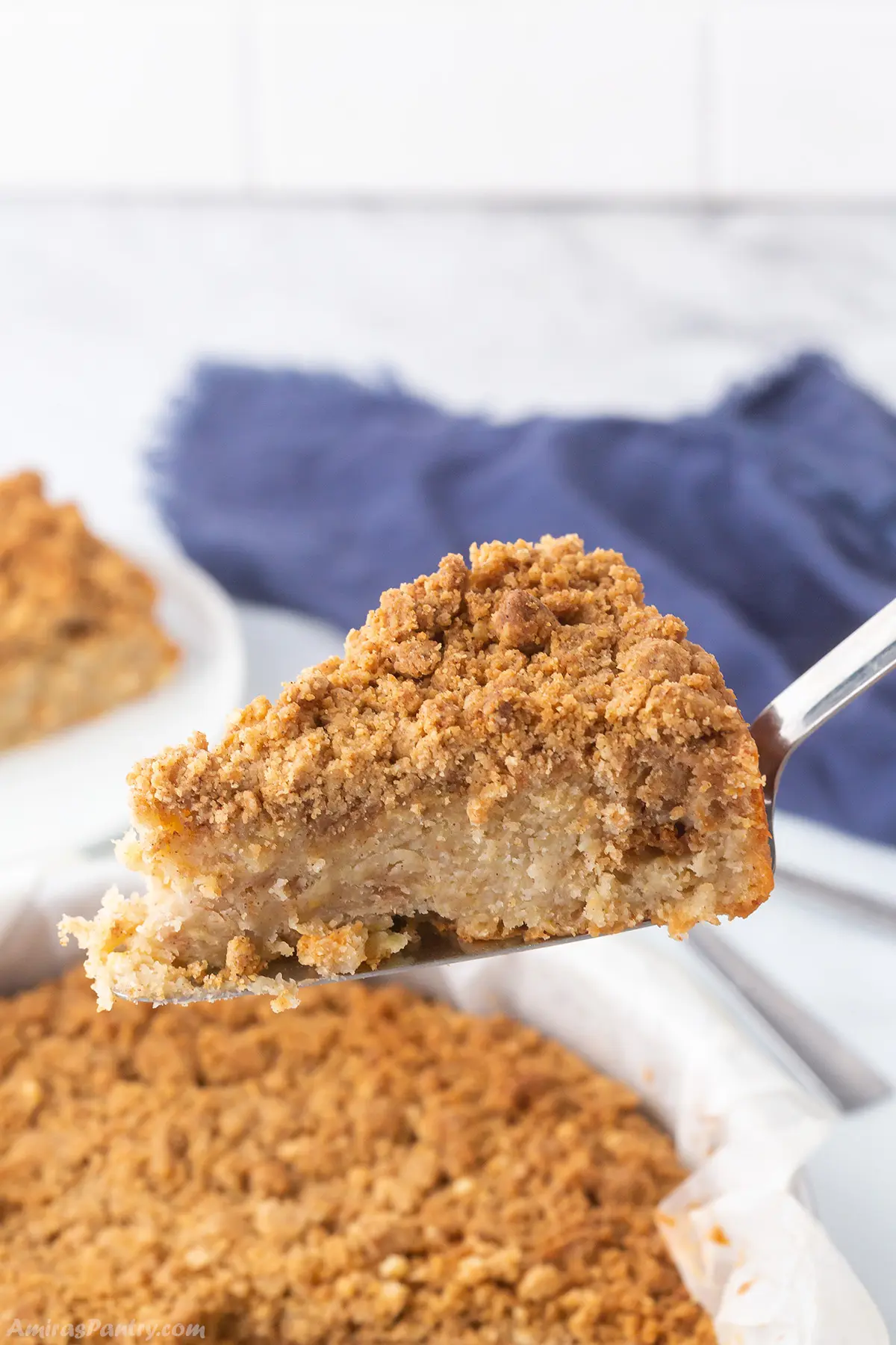 A close up look at a slice of apple crumb cake.