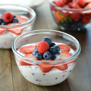 A close up image of a bowl with creamy fruit salad.