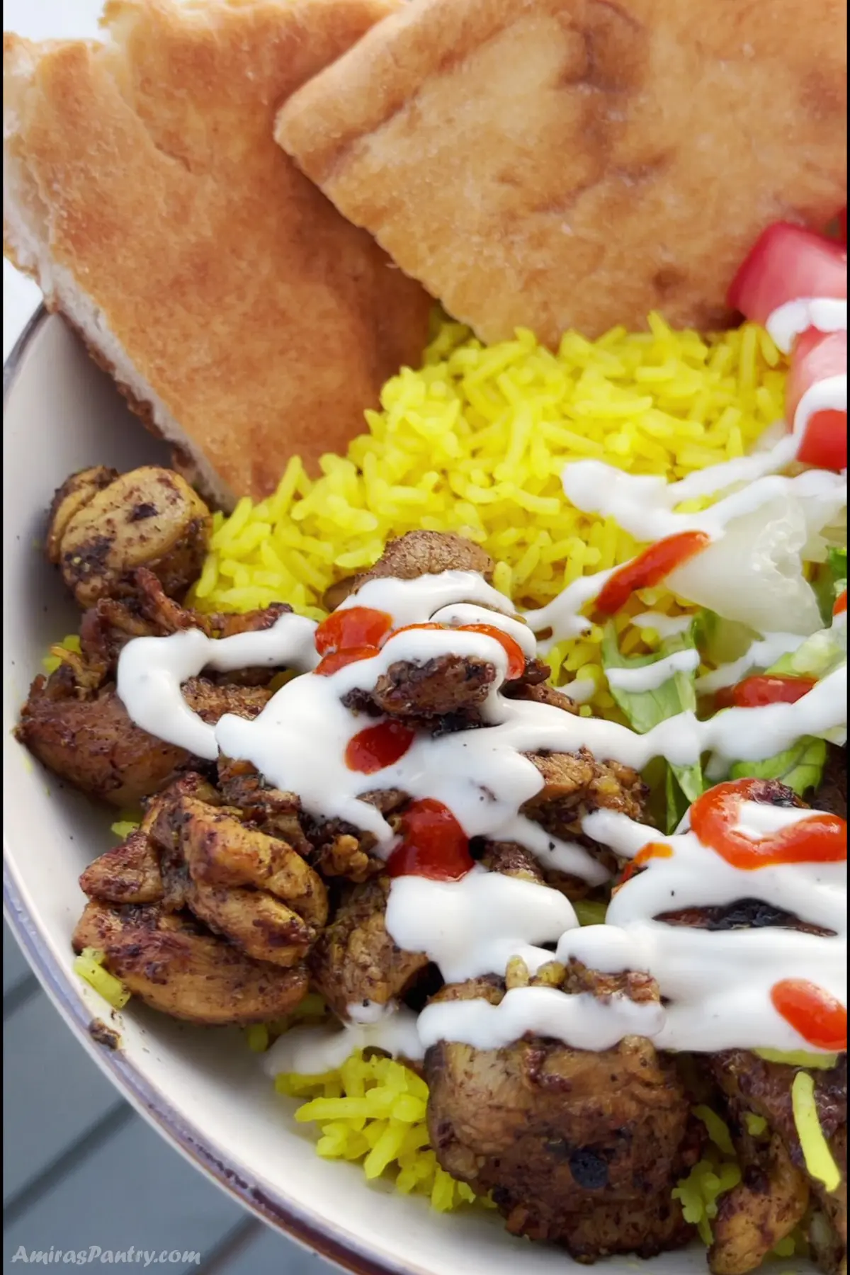 A close up look at a bowl of Halal chicken over rice.