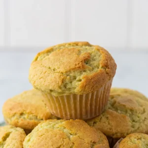 Stack of pistachio muffins on a white plate.