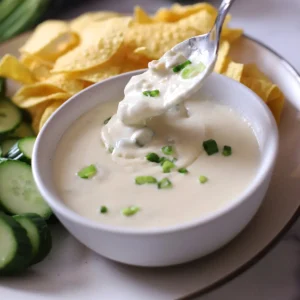 A spoon with some creamy sour cream sauce.