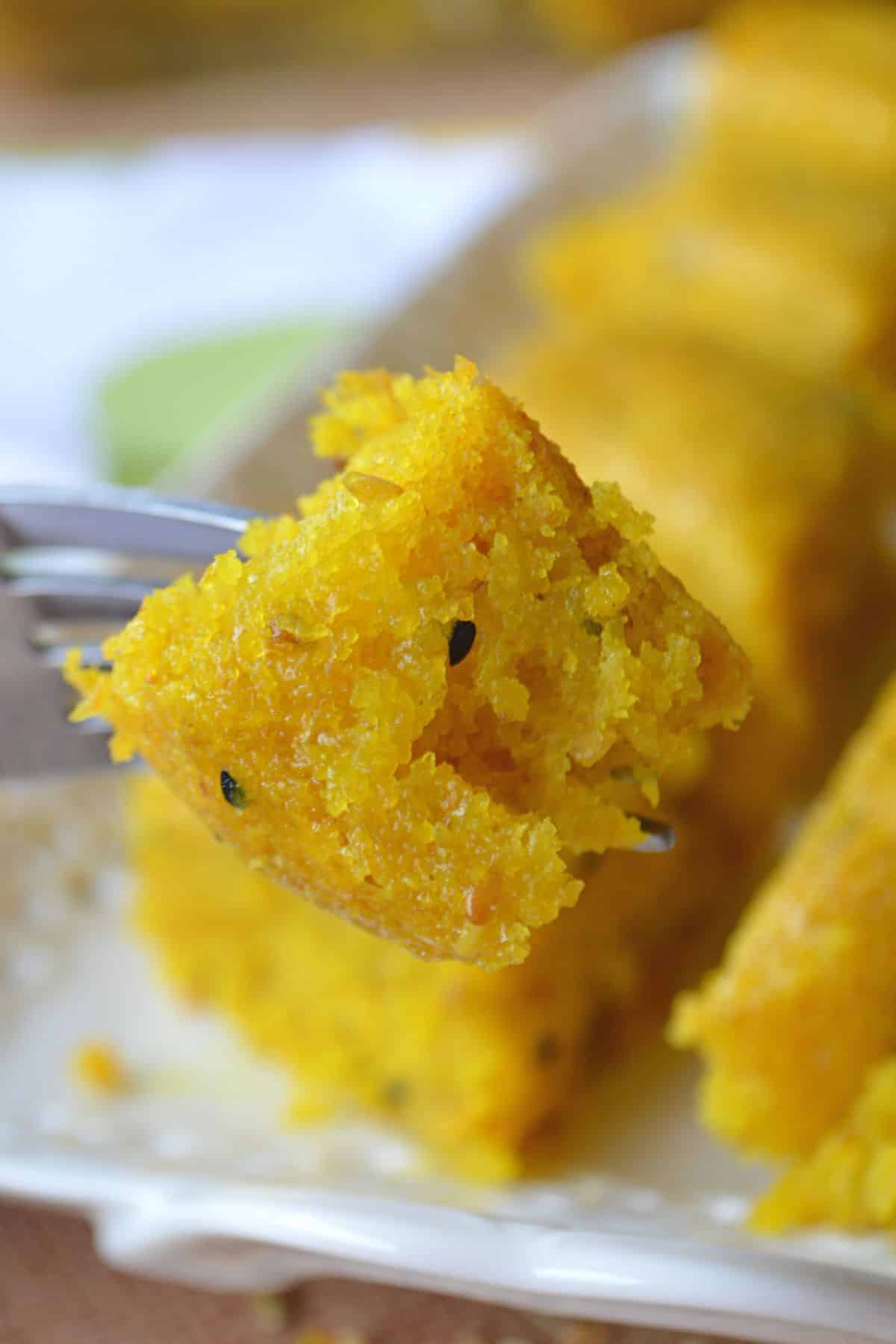 A fork holding a piece of turmeric cake.