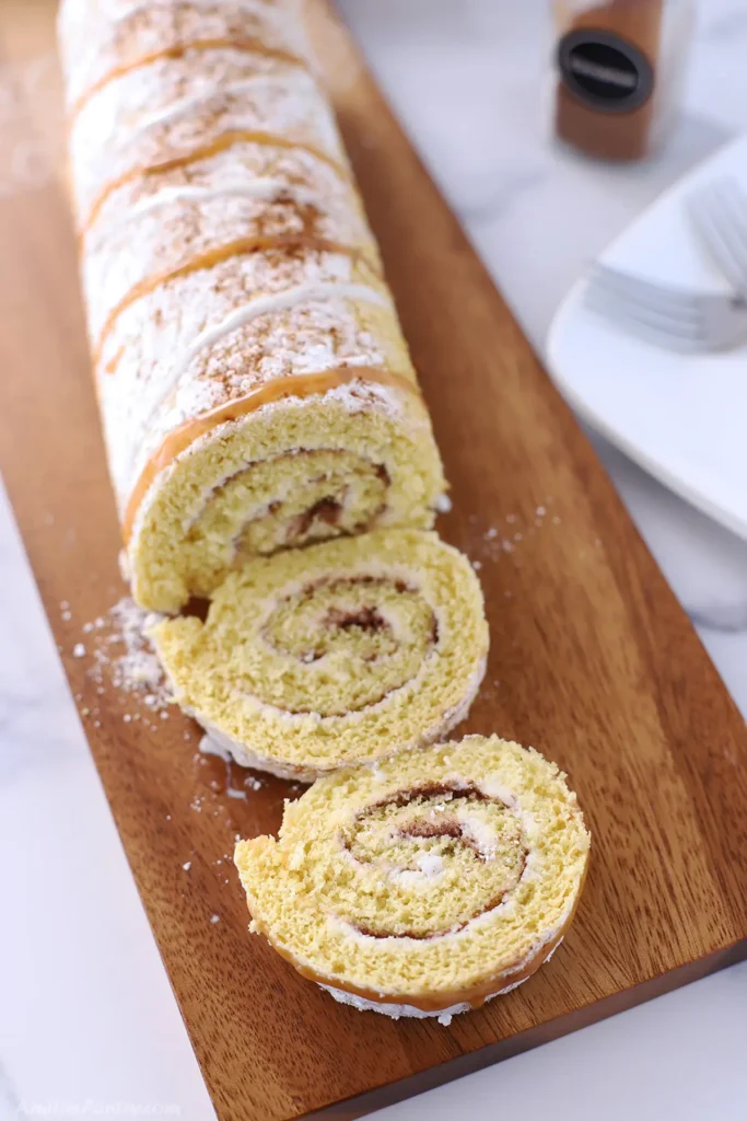 Cinnamon cake roll on a wooden cutting board.