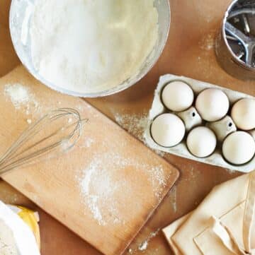 Baking ingredients with eggs on a wooden table.