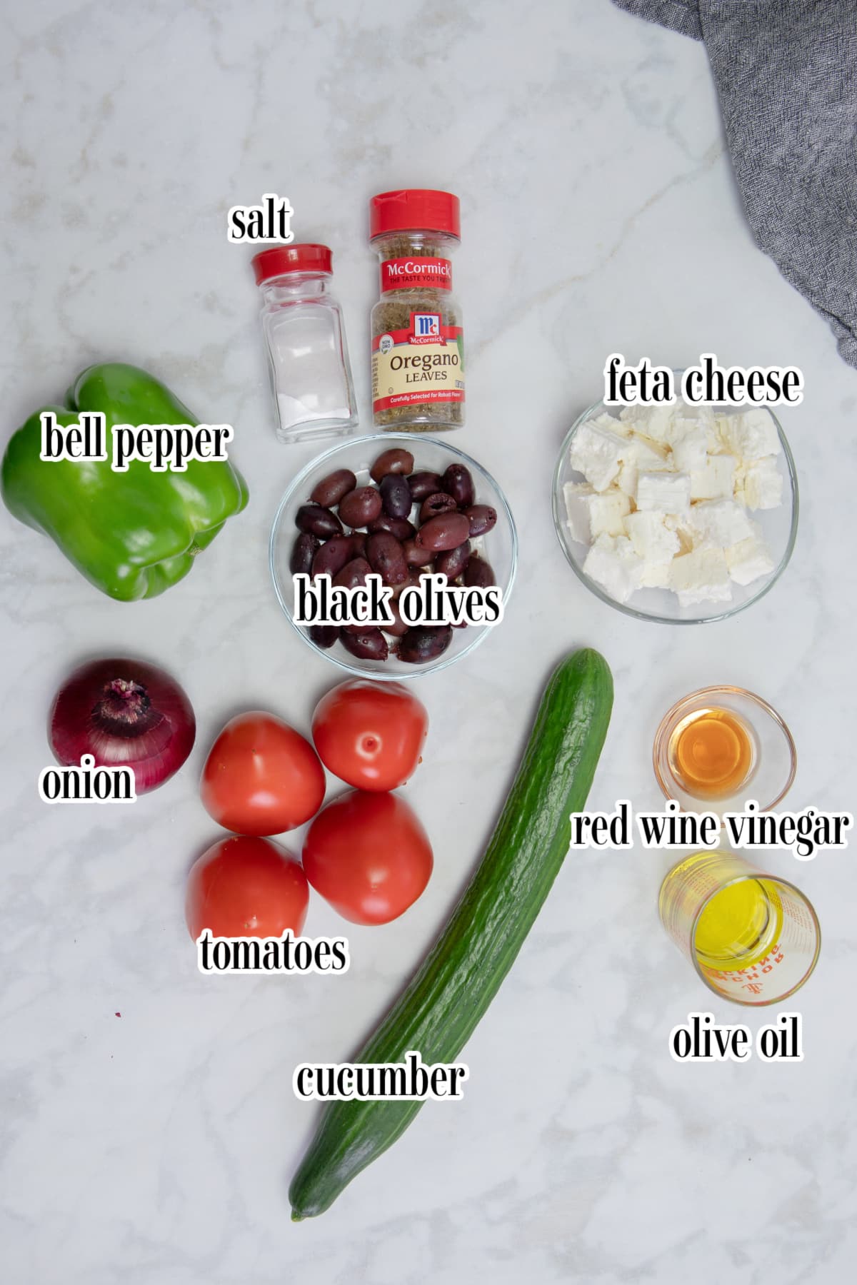 Greek salad ingredients on a white surface.