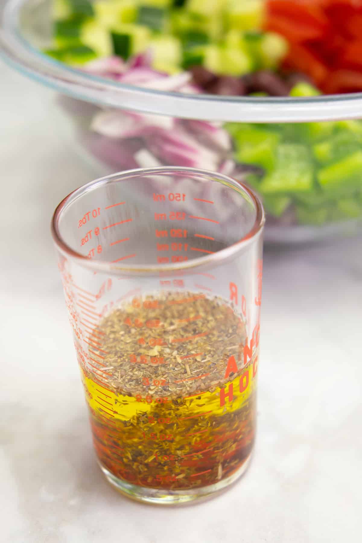 Greek salad dressing in a small cup.