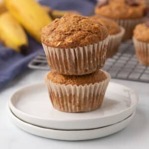 Two stacked banana muffins on a white plate.