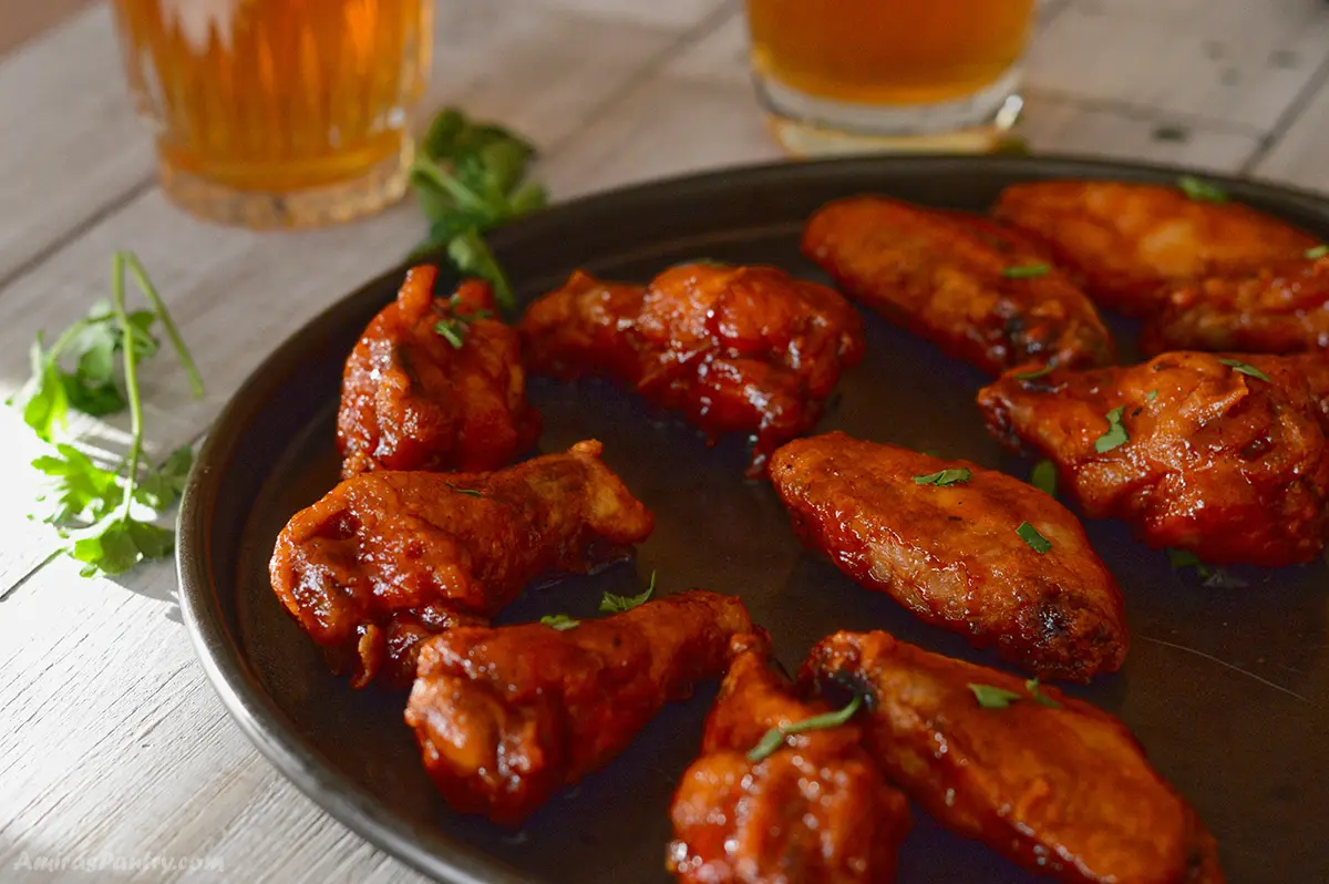 BBQ wings on a serving tray with juice on the back.