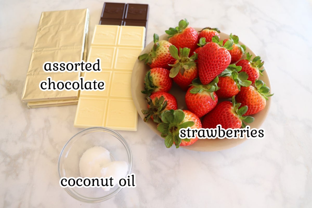 Chocolate covered strawberries ingredients on a white surface.