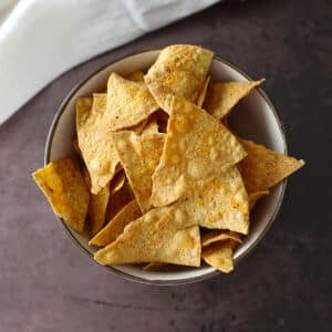 A top view of a bowl with a pile of homemade doritos.