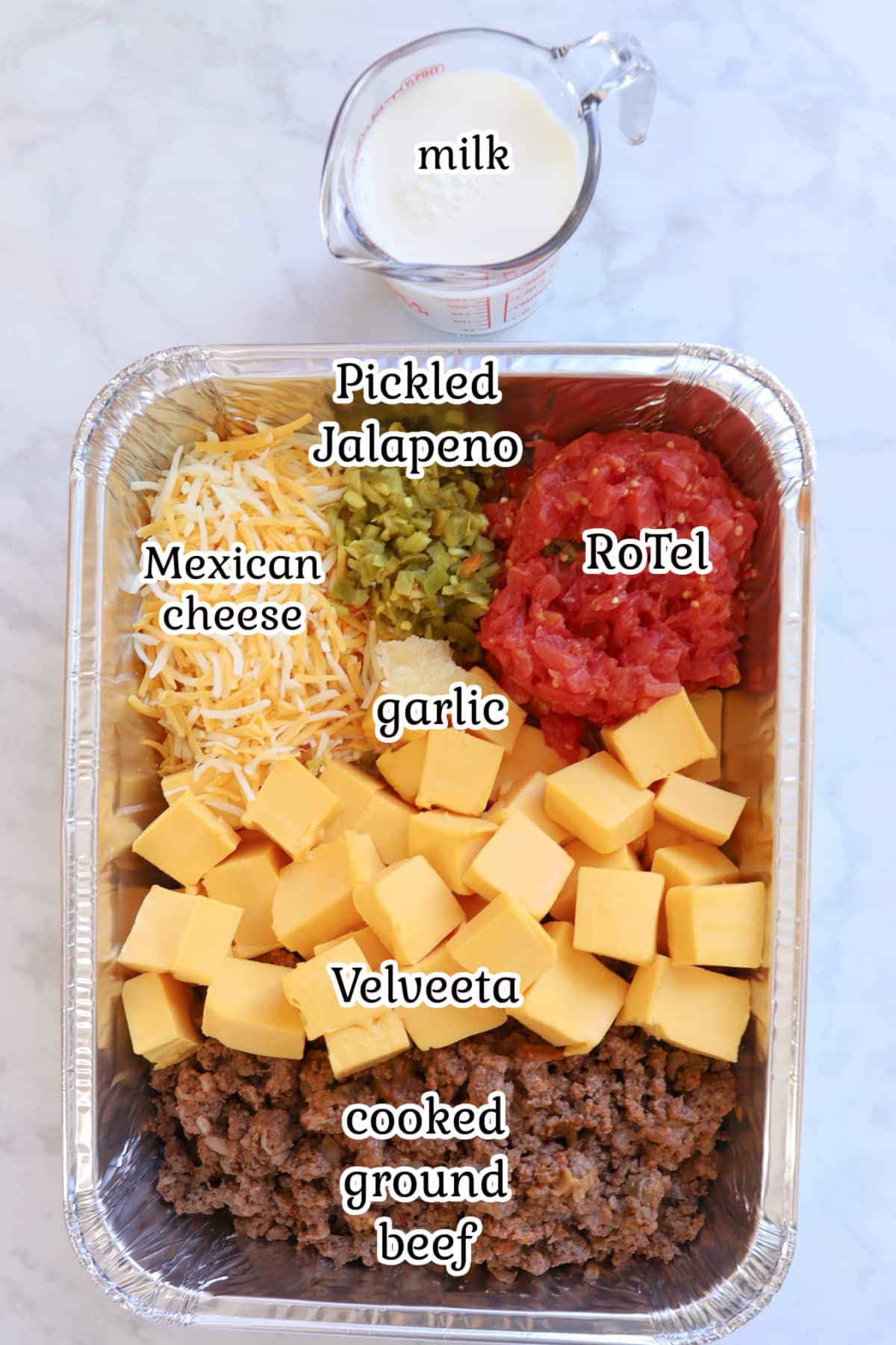 Smoked queso ingredients in a foil pan.