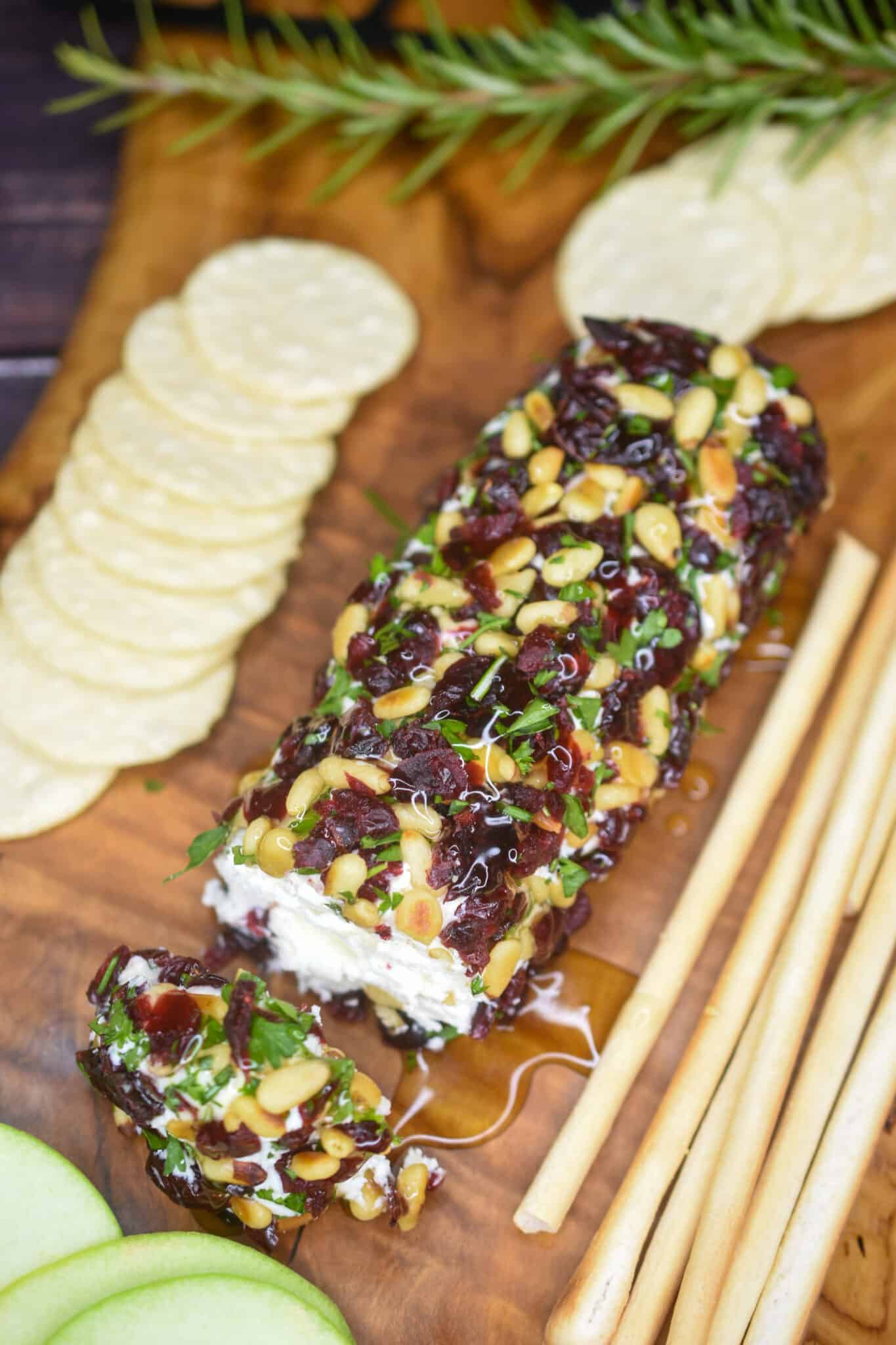 Goat cheese roll on a cutting board with crackers.