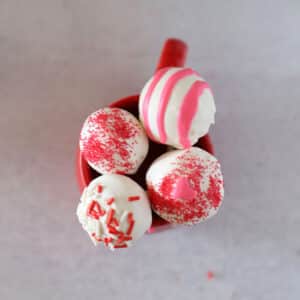A top view of cake pops in a red mug.