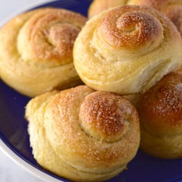 A close look at a plate with a pile of sweet rolls.