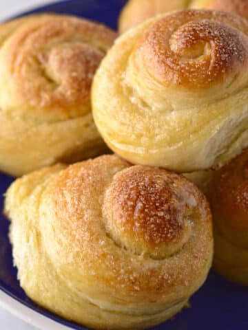 A close look at a plate with a pile of sweet rolls.