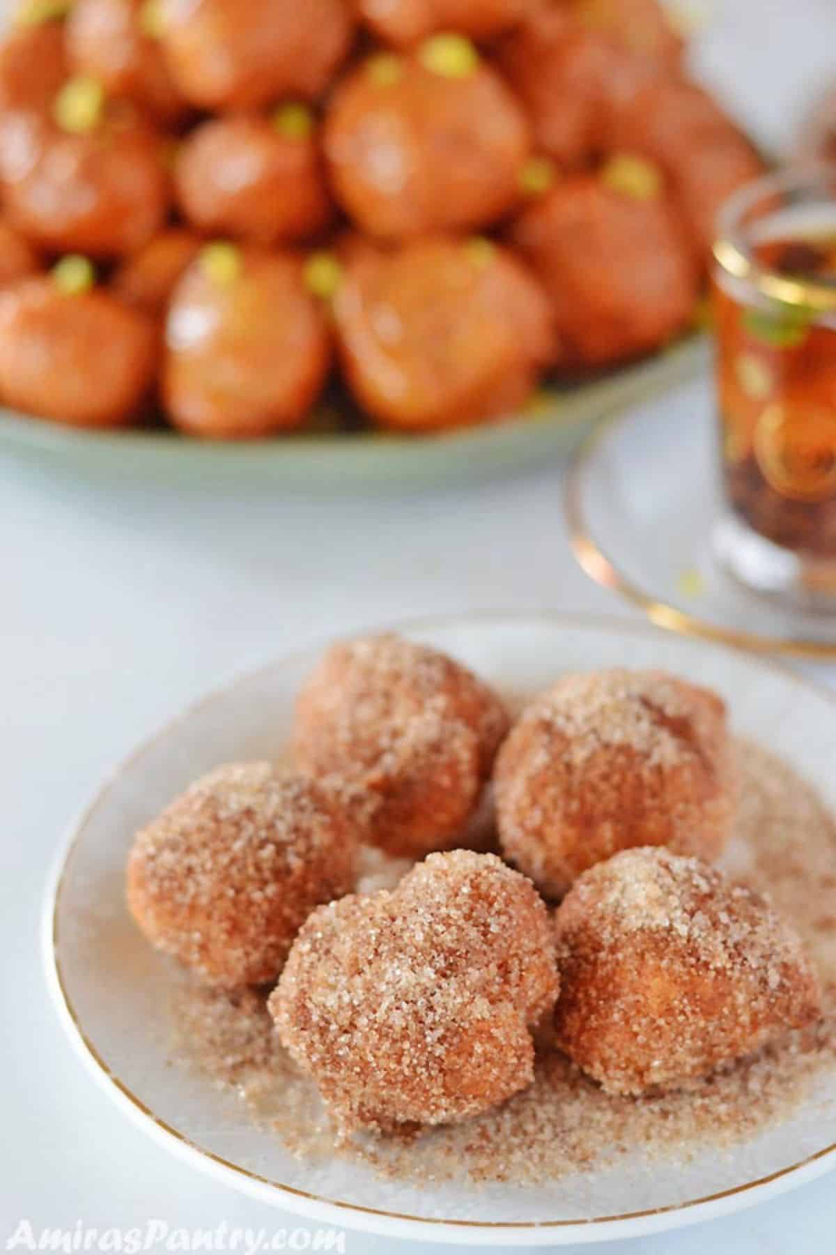 A dessert plate with lokma balls dusted in cinnamon sugar.