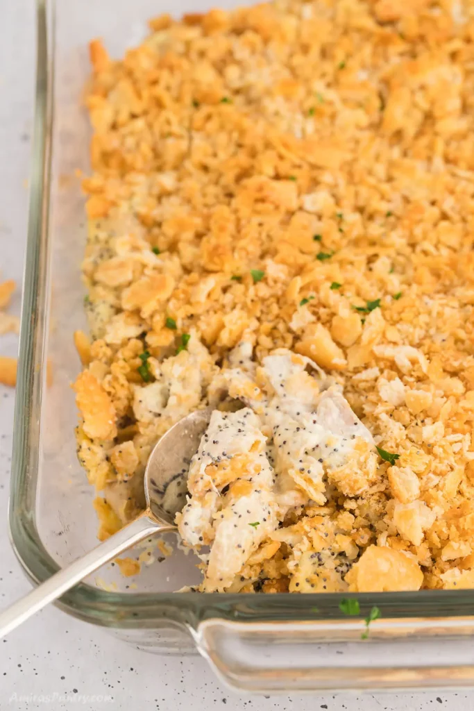 A top view of poppyseed chicken casserole with a spoon in it.