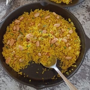 An overhead view of a skillet with yellow turmeric rice.