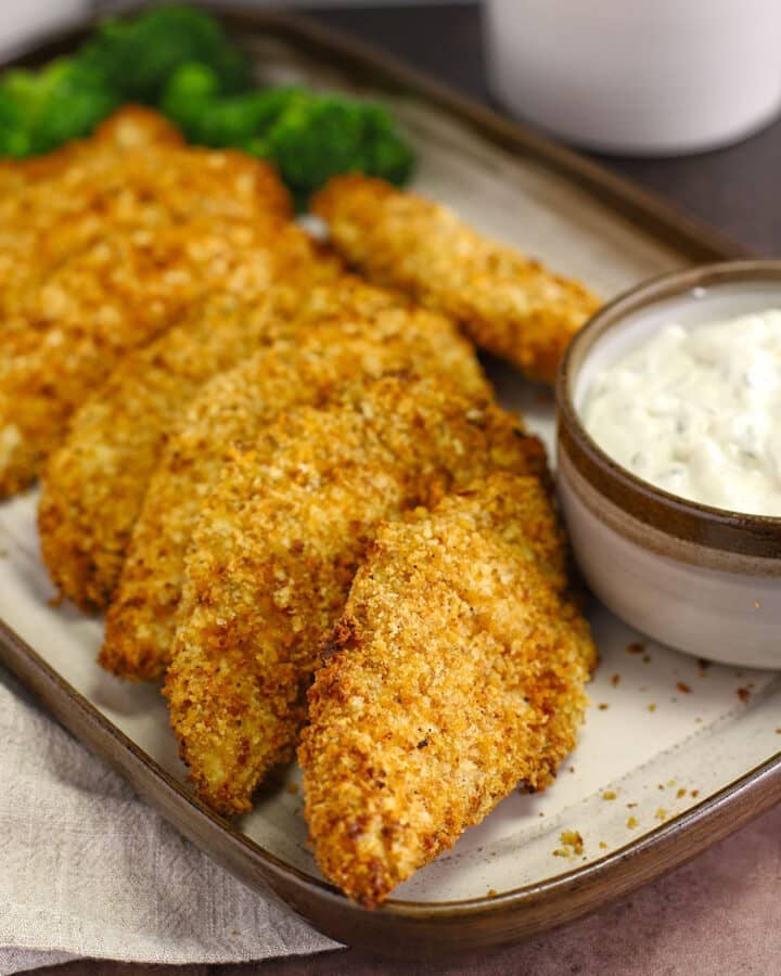 Breadded chicken tenders on a serving platter.