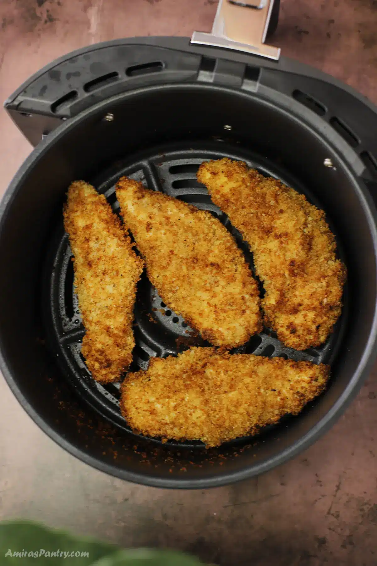 Chicken tenders in the air fryer basket.