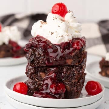 Two pieces of black forest brownies on a dessert plate.