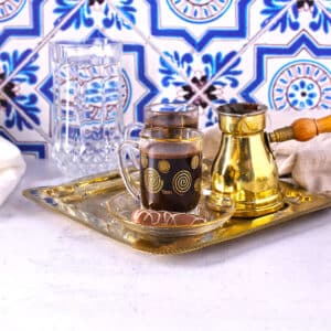 A table with a try of Turkish coffe cups along with pot and water.