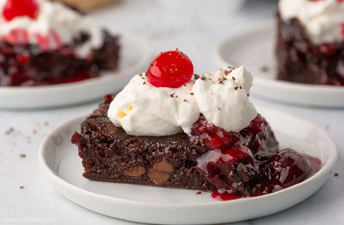 A piece of black forest brownies on a dessert plate.