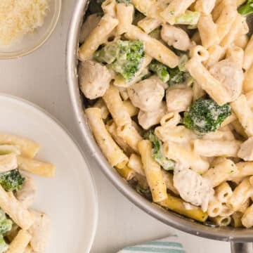 A top view of a pan and a serving plate with chicken broccoli ziti.